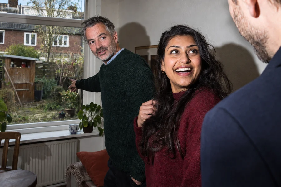 AI-conceptfoto van een adviseur en enthousiaste koper tijdens een woningbezichtiging.