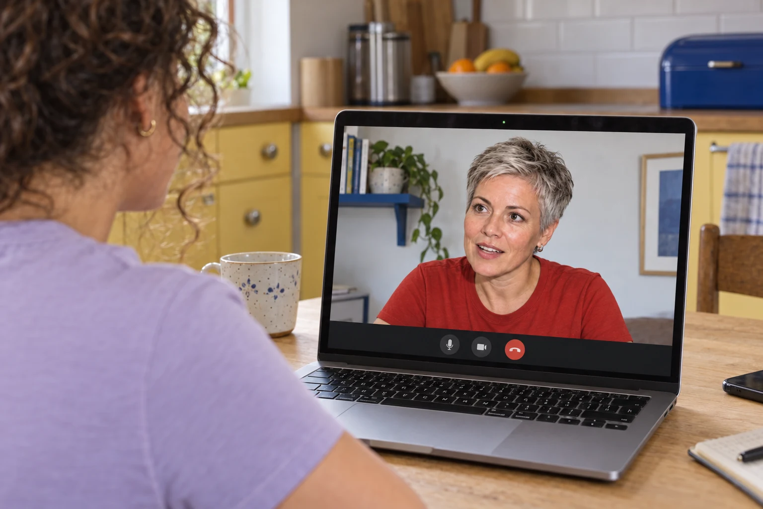Een koper spreekt haar aankoopadviseur via een videogesprek op haar laptop.